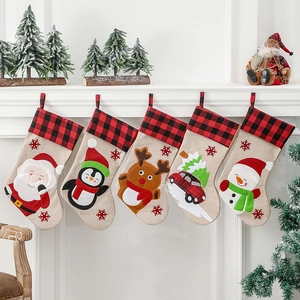 Set of 5 Christmas stockings with plaid cuffs and festive characters on a fireplace mantle