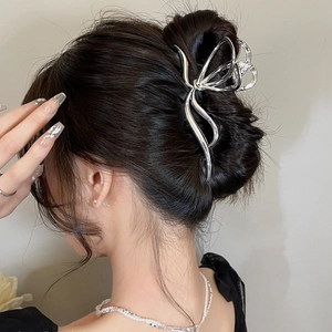 Rear view of a silver butterfly shark clip in hair showing elegant y2k metallic luster