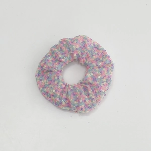 Detail of colorful sequins and mesh fabric on a glowing LED scrunchie accessory