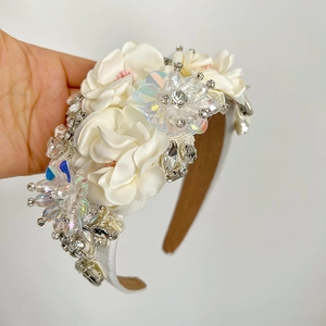 Luxurious handmade headband featuring white satin flowers and sparkling rhinestones