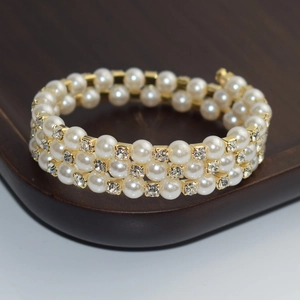 Detailed view of triple-layer gold bracelet with white pearls and sparkling rhinestones