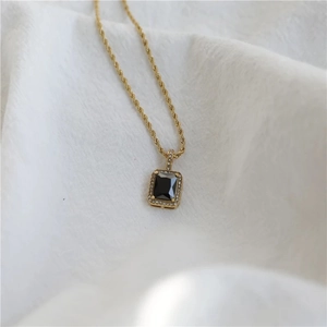 Detail of a vintage gold twist chain necklace with black rectangular zircon pendant