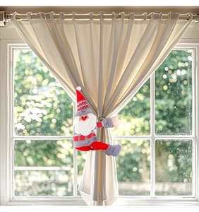 Detail of plush Santa Claus curtain tieback used on soft fabric in home decor
