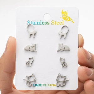 Macro shot of 4 pairs of stainless steel cat stud earrings held on a display card