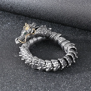 Punk vintage dragon cuff bracelet in silver with gold horns and green gemstone eyes