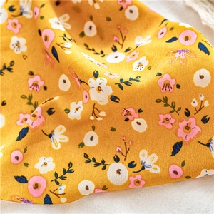 Detailed macro view of yellow floral pattern on soft chiffon fabric with elegant drapes