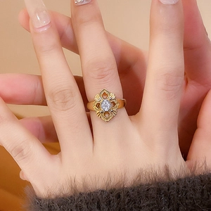 Detailed close-up of a 24K gold-plated openwork flower ring with a center zircon