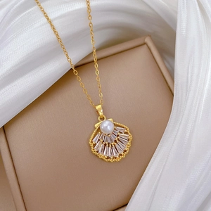 Detailed macro of gold shell pendant with pearl and crystals on a silk background