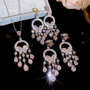 Détails d'un ensemble collier et boucles d'oreilles papillon argentés à franges cristal