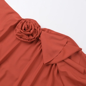 Detalle de la rosa de tela artesanal y pliegues delicados en el vestido rojo