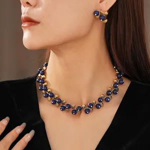Vintage jewelry set with blue stones and gold flower petals on a velvet shirt
