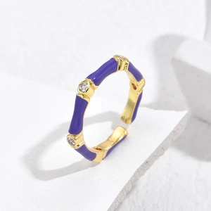 Detail of gold-plated bamboo texture ring with purple enamel and zircon inlay