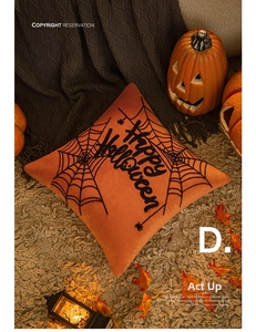 Macro shot of Halloween pumpkin orange plush pillow with Happy Halloween embroidery detail