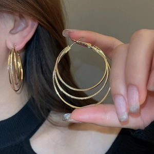 Detailed view of layered gold circular earrings featuring a modern geometric hoop design