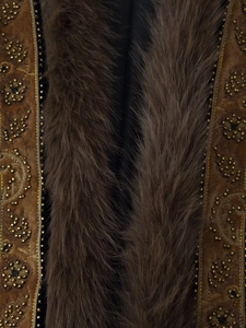 Detailed close-up of intricate gold bead embroidery and luxurious brown fur on the vest