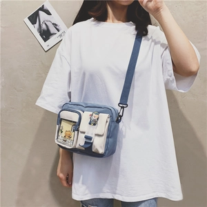 Detail of color-block canvas crossbody bag with astronaut ornament and transparent slot