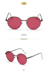 Detail view of round gunmetal sunglasses with dark red lenses from multiple angles