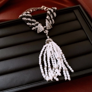 Detail of vintage necklace with black resin links, pavé rhinestones and pearl tassels