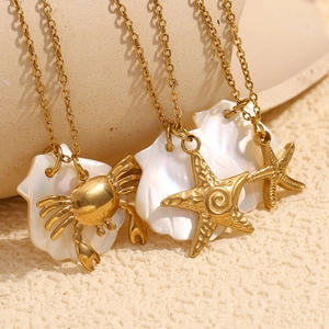Detail of 18K gold starfish and crab charms on shell pendants with stainless steel chains
