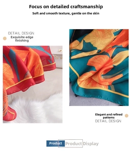 Detail of silk-like scarf featuring orange floral print and premium rolled hem edges