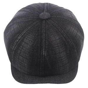 Detail of deep black newsboy cap featuring 3D grid texture and classic panel construction