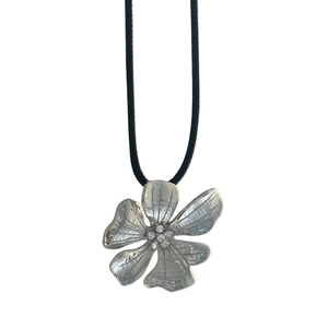 Detail of silver five-petal flower necklace with hammer texture and zircon center