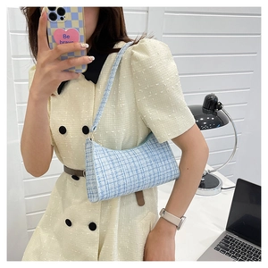 Détail du sac bandoulière en tweed bleu clair et blanc avec fermeture éclair en métal