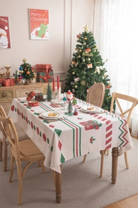 Detailed Christmas tablecloth featuring gift box and holly prints on a wooden table