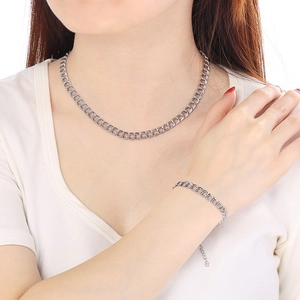 Detail of silver double curb chain necklace and bracelet set worn by a model