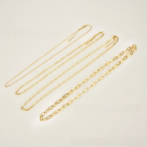 Detail view of four gold-plated paperclip link necklaces in varying thickness and sizes