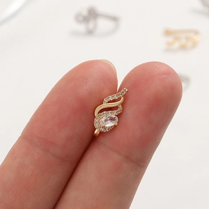 Detailed close-up of golden wing-shaped nose clip with shimmering cubic zirconia stones