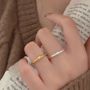 Close-up of minimalist gold and silver twisted rings with rectangular accent for women