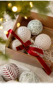 Detailed view of 8cm white embossed Christmas balls with festive glaze in a gift box