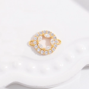 Détail du connecteur rond doré avec pavé de zircone cubique et deux anneaux de suspension