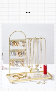 Macro detail of golden iron art jewelry display stand with multi-layer hooks and base