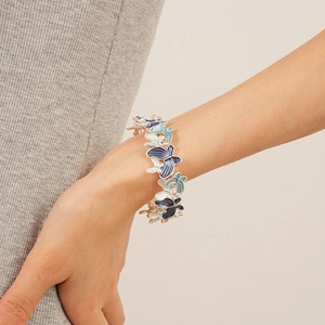 Detail of blue gradient enamel butterfly bracelet on wrist for an elegant style