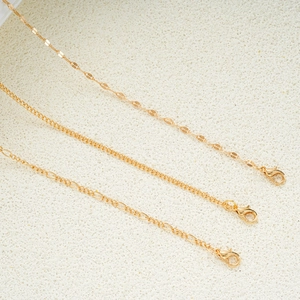 Three-piece set of minimalist gold sequin and figaro chains with lobster clasps on stone