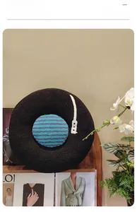 Close-up of circular vinyl record plush pillow made of soft black faux shearling fabric