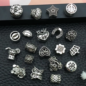 Macro shot of silver alloy charm beads with peace and heart motifs for DIY jewelry