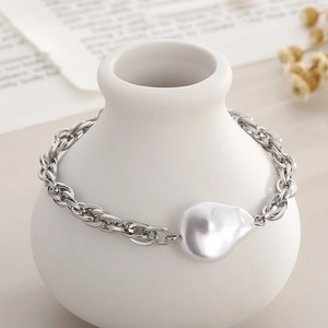 Baroque pearl bracelet on white ceramic vase with minimalist aesthetic jewelry display
