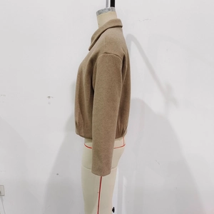 Détail d'une veste courte en laine kaki avec col classique et fermeture éclair
