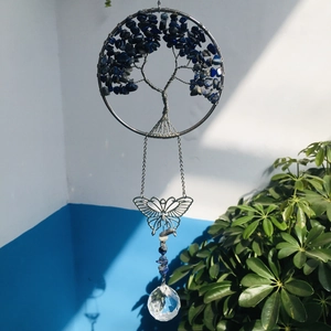 Detail of life tree suncatcher with blue stones, metal butterfly and crystal ball
