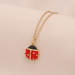 Dettaglio del ciondolo coccinella dorata con smalto rosso e micro-pavé di zirconi cubici