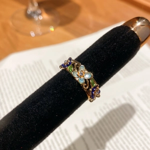 Detail showing the colorful enamel flower petals and micro zircon center on a gold ring