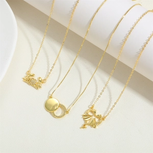 Golden crab and dragon pendant necklace set with zircon accents on minimalist white background