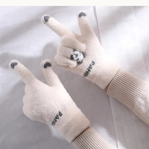 Close-up of cute winter knit gloves detail featuring a playful panda design and touch screen.