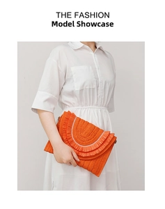 Detail of an orange woven straw clutch with tiered ruffled edges for a summer holiday look