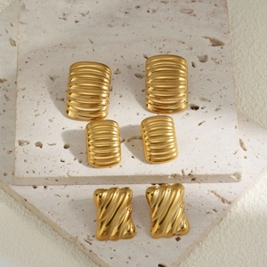 Three pairs of gold rectangular earrings with ribbed texture on natural stone base