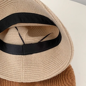 Beige knitted bucket hat with adjustable inner strap and premium woven texture detail