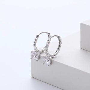 Close-up of S925 sterling silver hoop earring with sparkling zircon and beaded texture